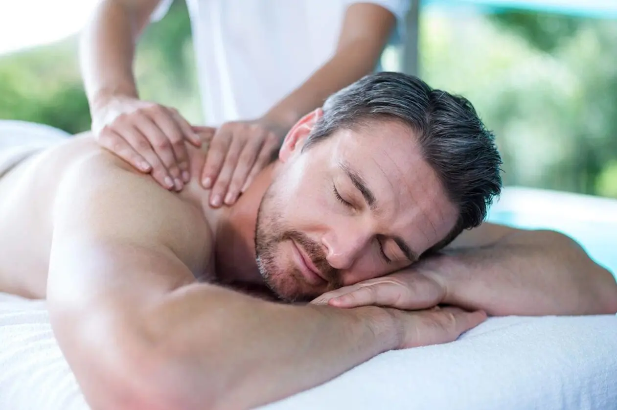A man getting his back turned while being massaged