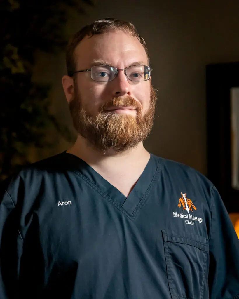 A man with beard and glasses wearing an apron.