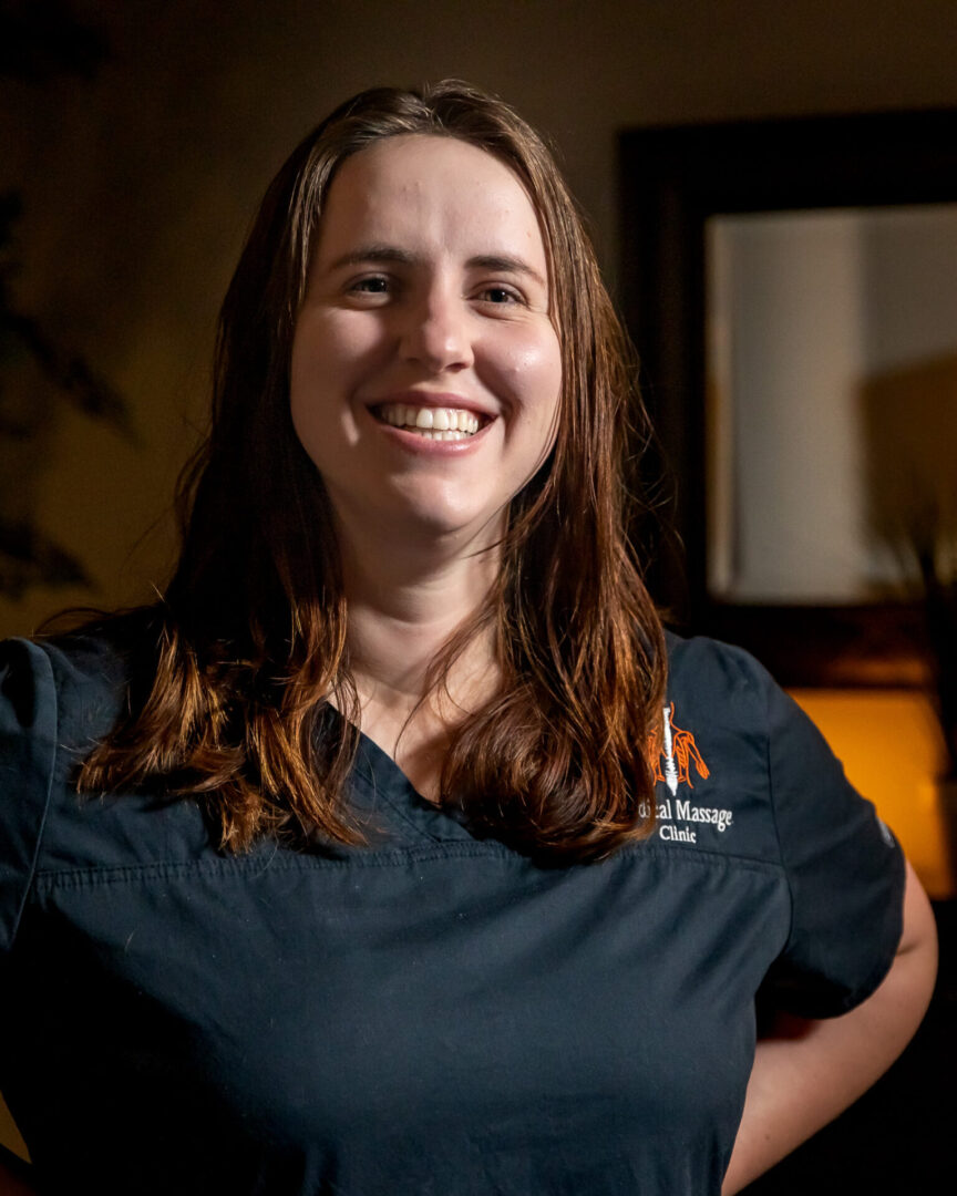 A woman in scrubs smiling for the camera.