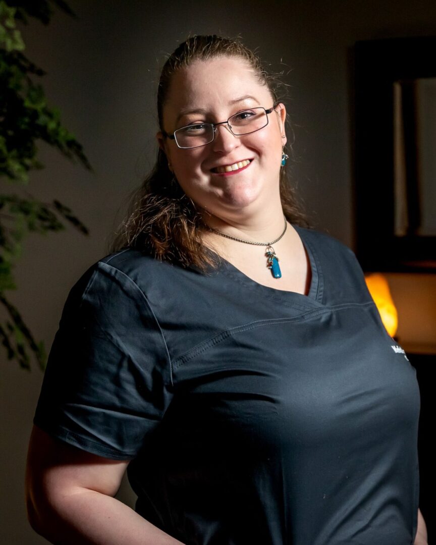 A woman standing in front of a lamp wearing glasses.