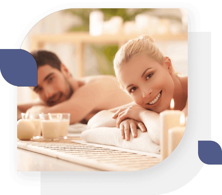 A man and woman laying on towels in a spa.